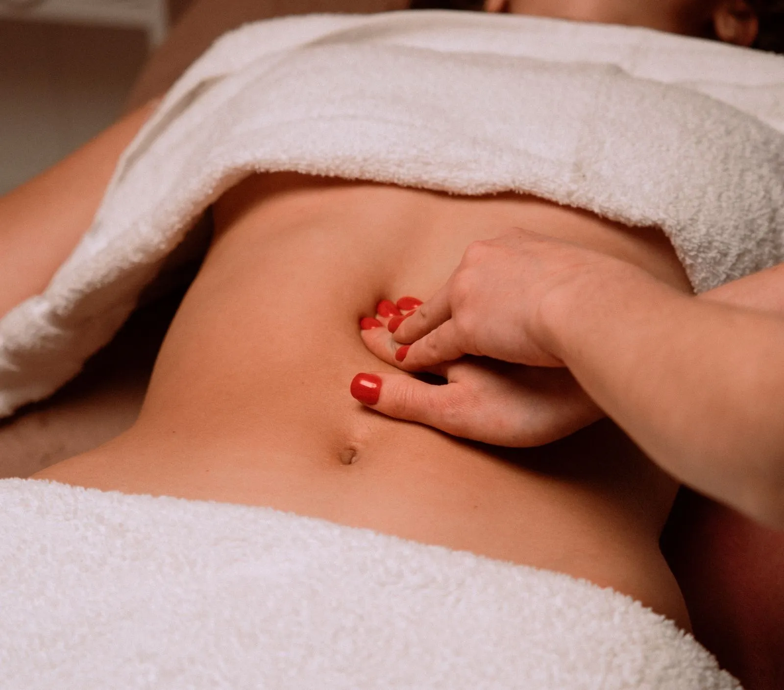 Cuidado manual delicado na região abdominal durante uma sessão terapêutica